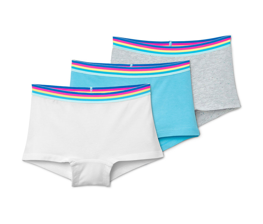 Tři dívčí kalhotky v bílé, modré a šedé barvě. Všechny mají barevný pas.