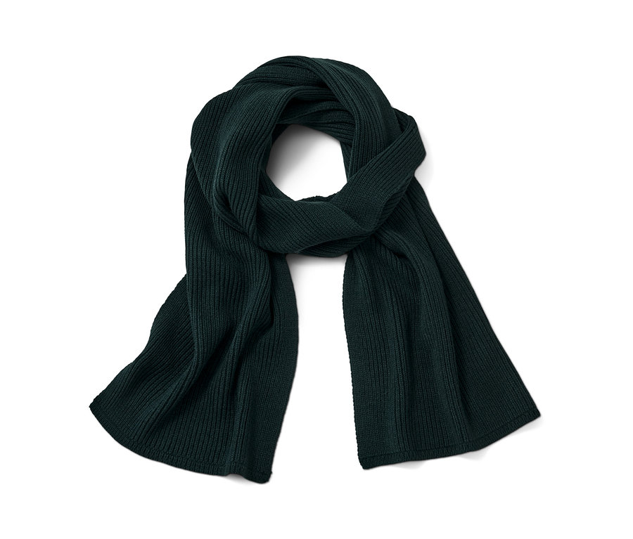 Tmavě zelená pletená šála leží zkroucená na bílém pozadí.