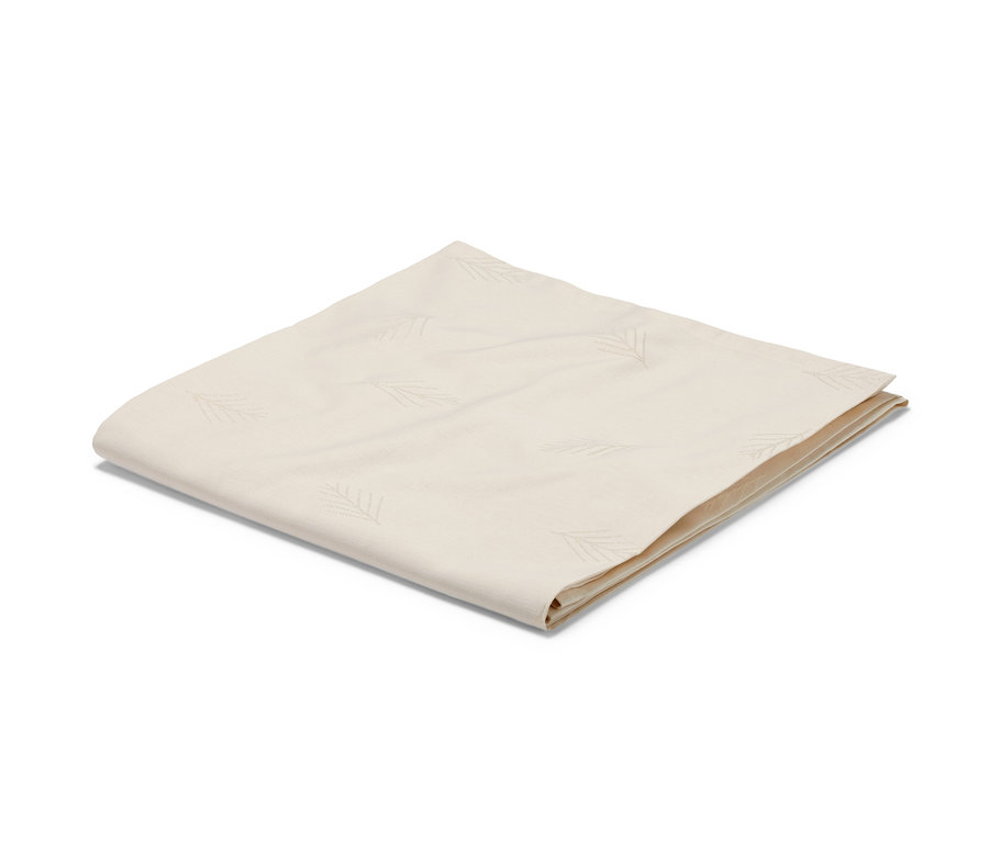 Krémově bílý žakárový ubrus standardní velikosti složený na bílém pozadí.