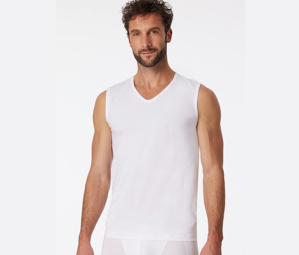 Muž má na sobě bílé tílko SCHIESSER s biobavlnou.