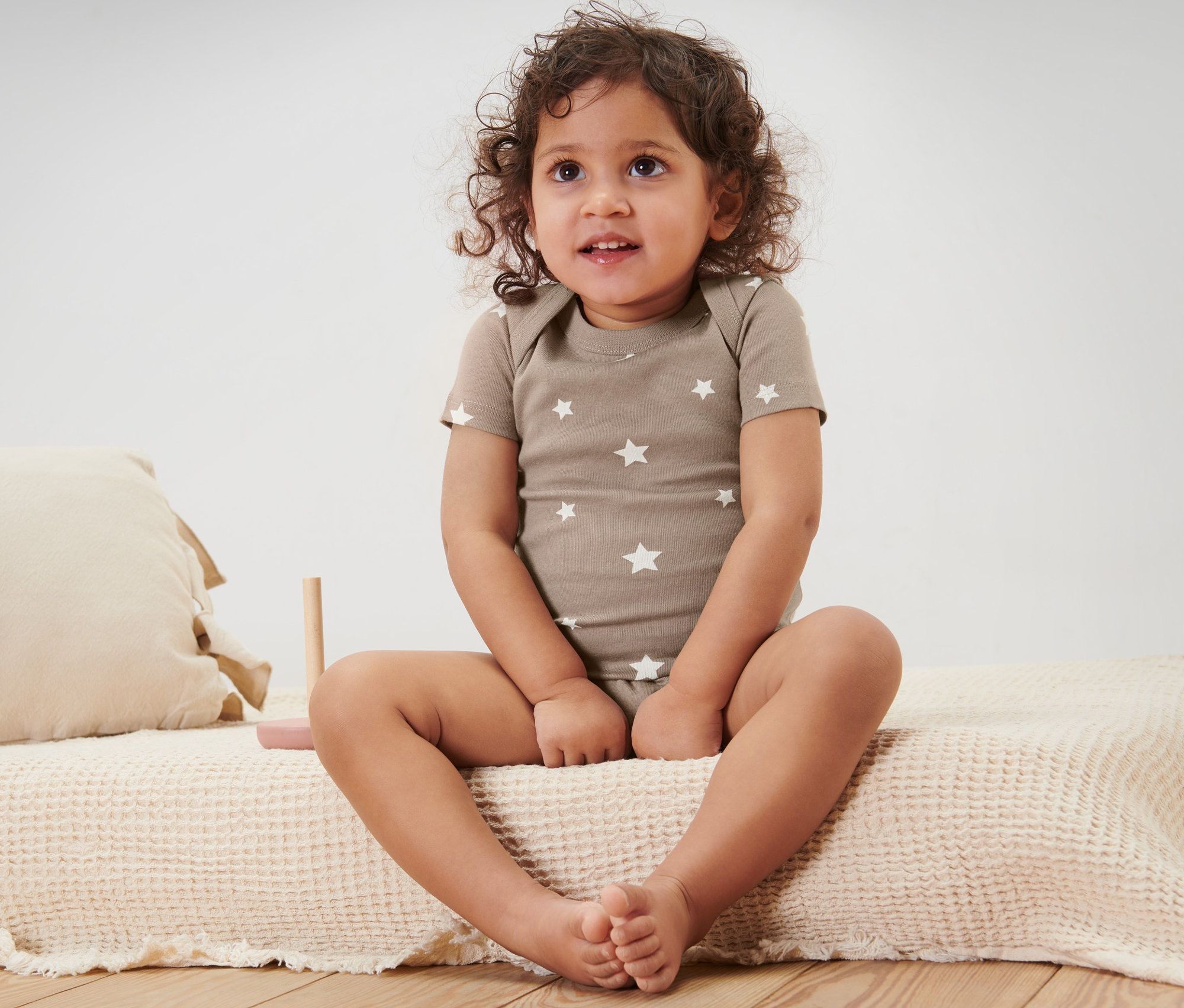 Dítě sedí na posteli a má na sobě body s krátkým rukávem, 5 ks.