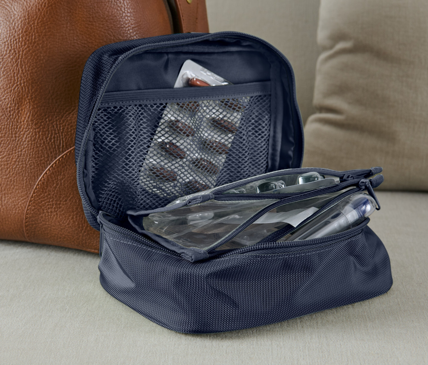 Otevřená modrá taštička na léky s platem léků v síťované kapse.