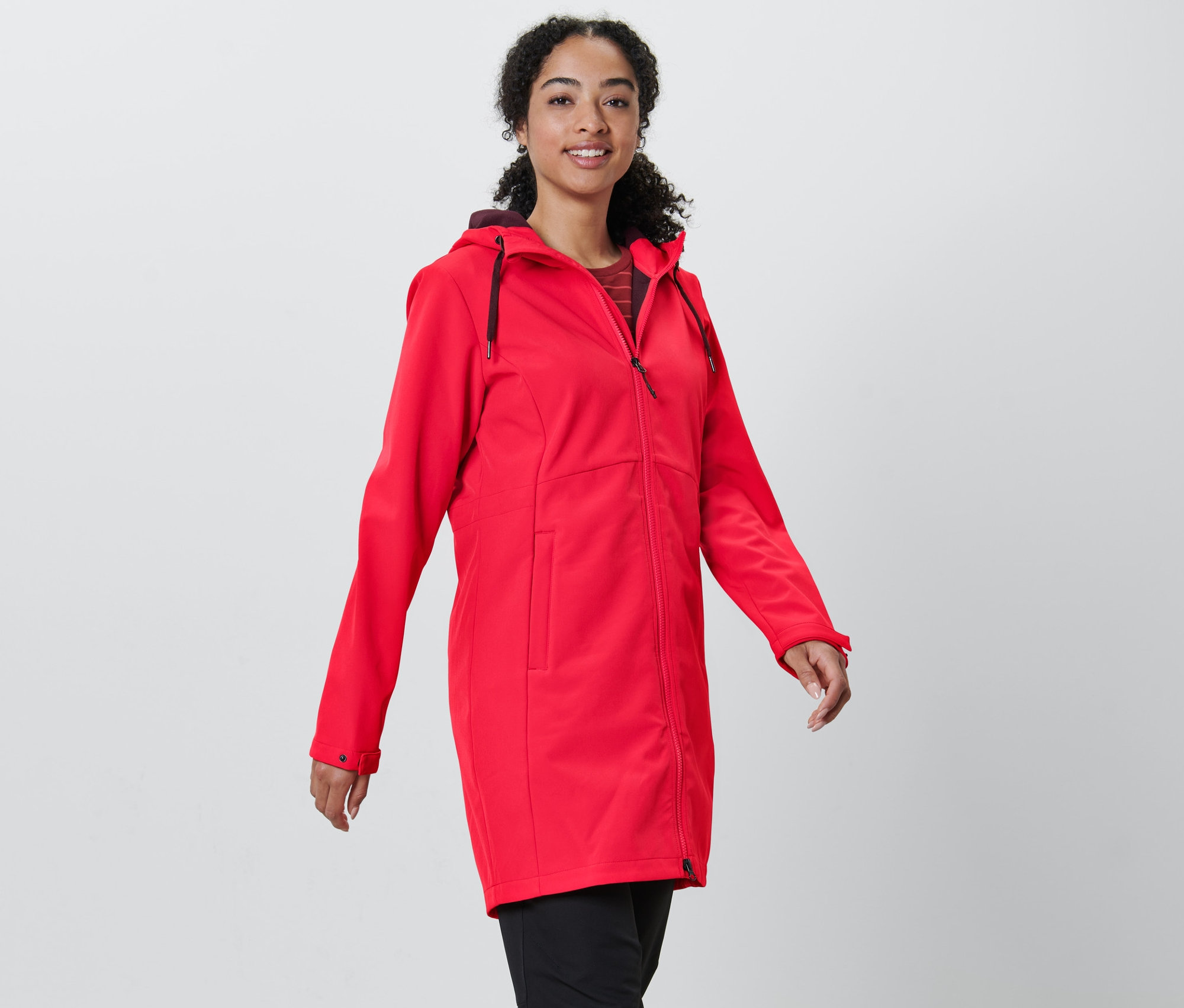 Žena má na sobě červený softshellový kabát.