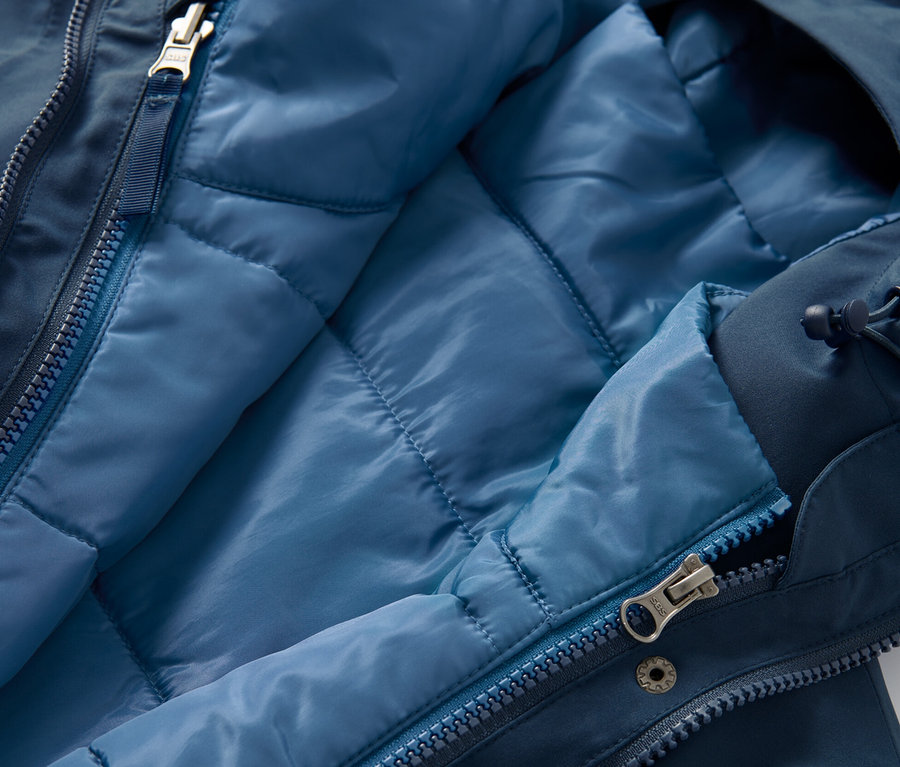 Detailní pohled na rozepnutý 3 v 1 funkční kabát s vestou, vnitřní strana vesty je světle modrá.
