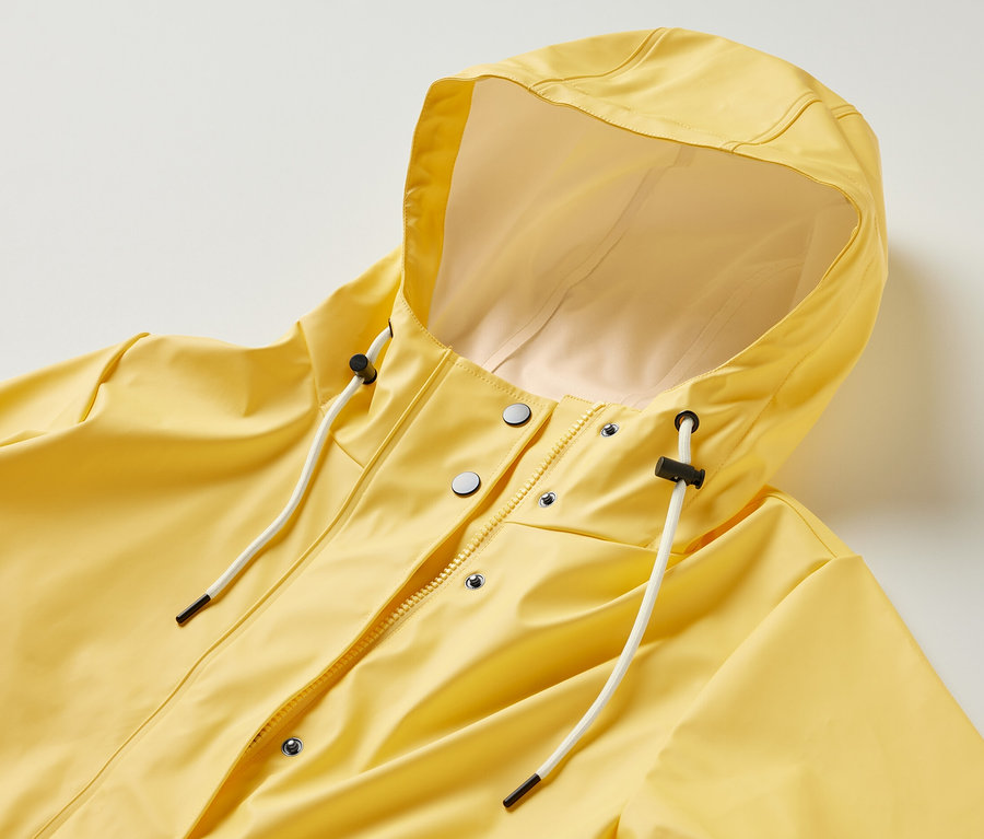 Žlutá pláštěnka »Friesennerz« s kapucí, zapínáním na zip a knoflíky.