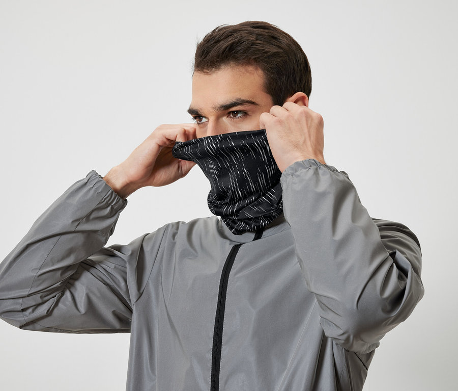 Muž si obléká černý nákrčník s bílými proužky a má na sobě šedou bundu.