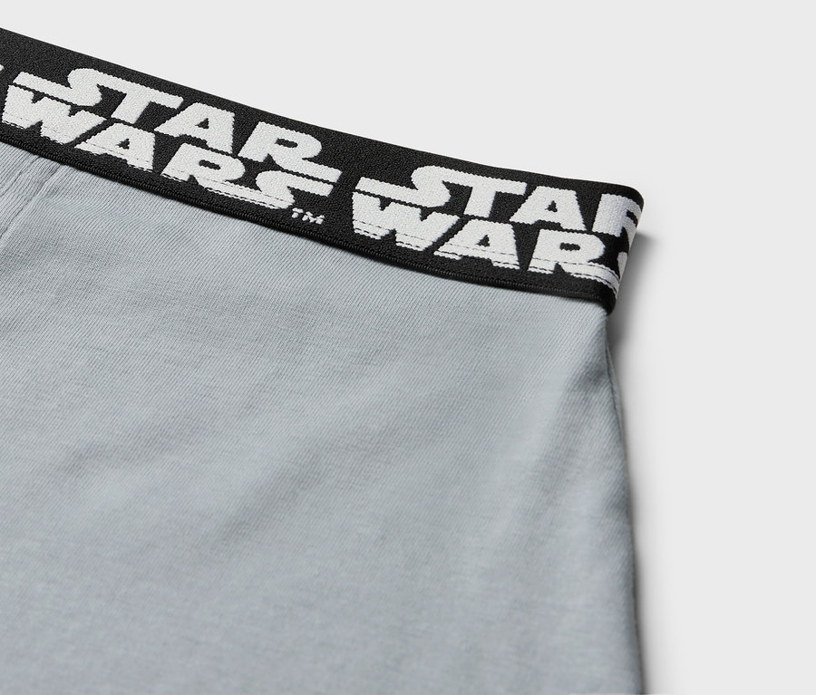 Detail šedých boxerek s černým pasem s bílým nápisem STAR WARS.