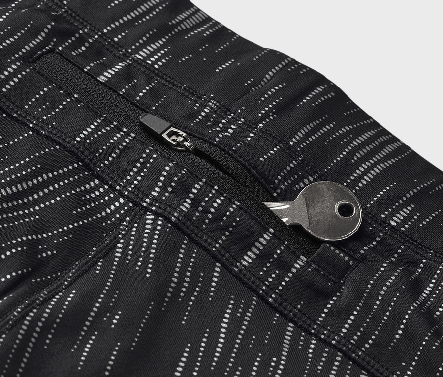 Detail černých legín se vzorem a klíčem v kapse na zip.