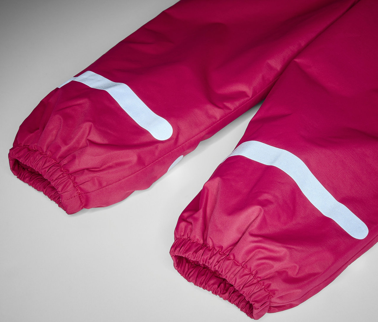 Detail dětských termo kalhot do deště bobulové barvy.