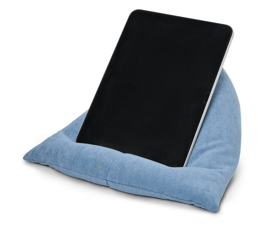 Tablet opřený o modrý polštář.