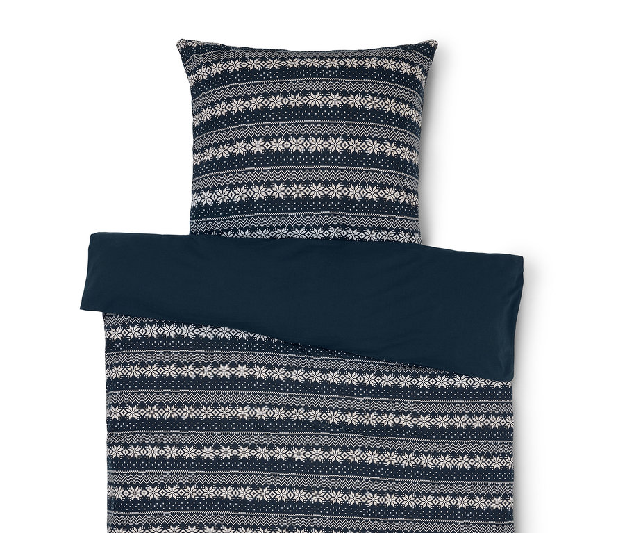 Povlečení s modrým a bílým vzorem sněhových vloček a jednobarevné modré povlečení.