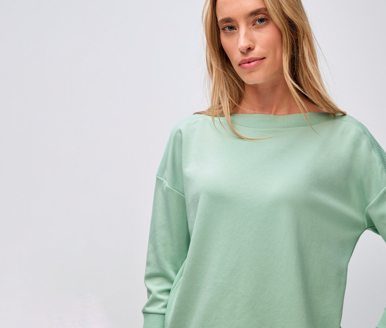 Žena má na sobě triko s žebrovaným detailem Street One, šalvějová zelená.