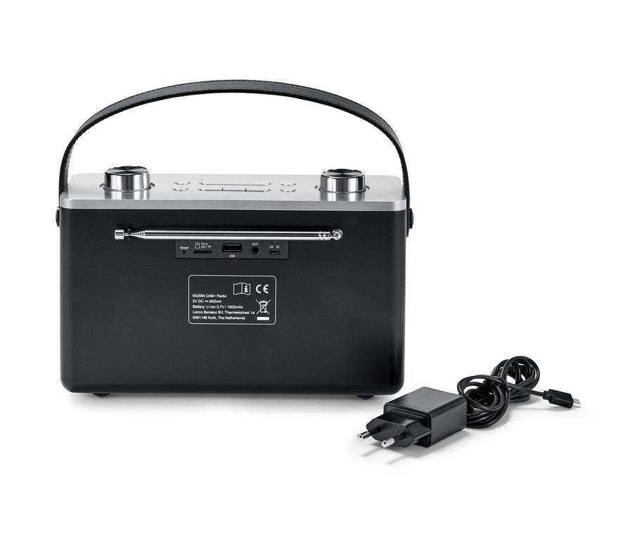 Černé digitální rádio DAB+/FM s Bluetooth® a napájecí adaptér leží vedle něj.