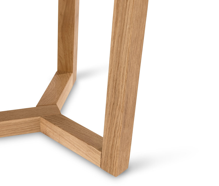 Detail nohy dřevěného stolku na bílém pozadí.