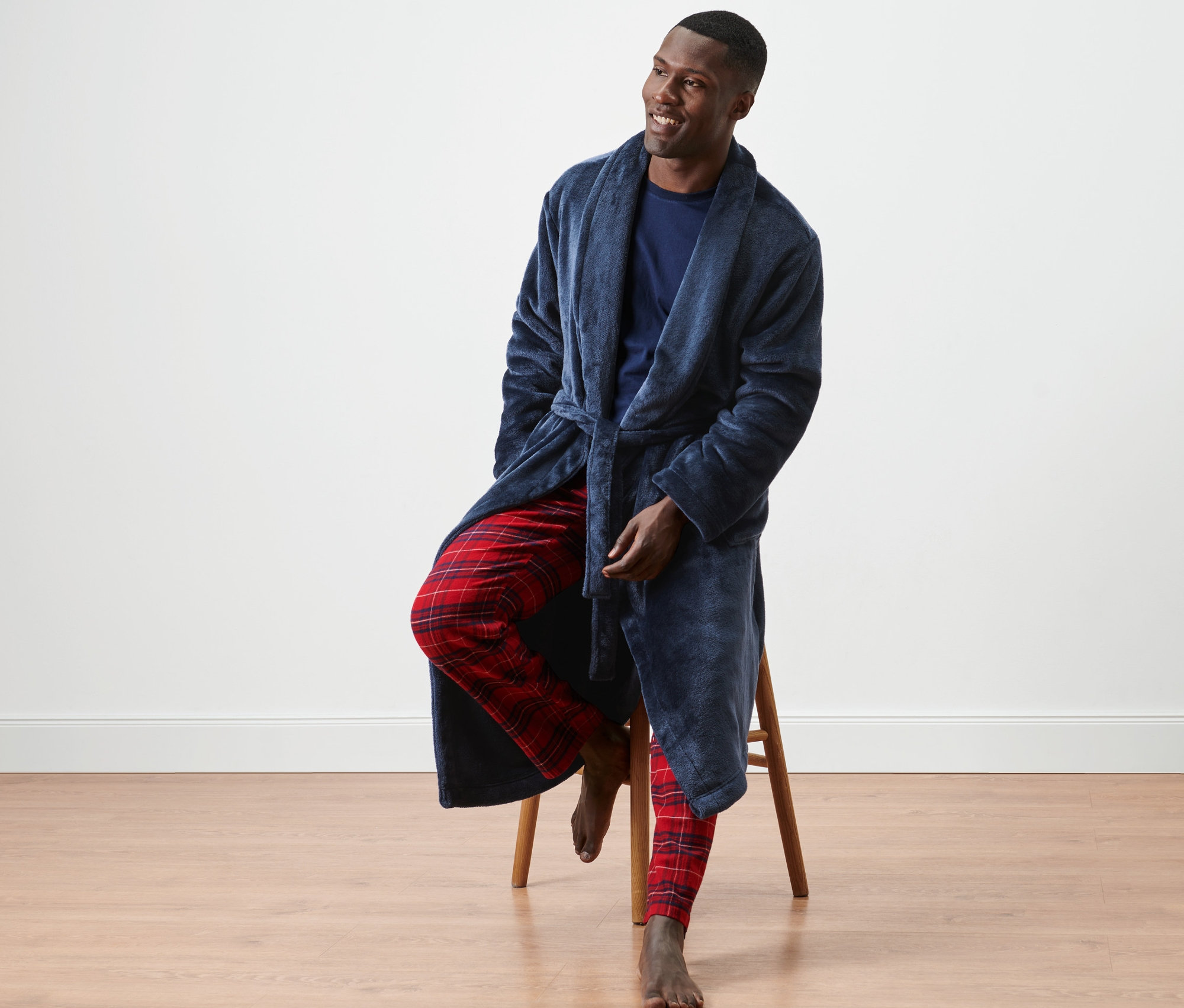 Muž sedí na stoličce v županu.