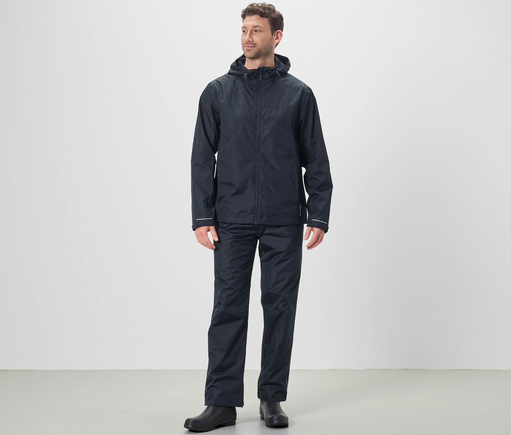 Muž má na sobě pláštěnku a kalhoty do deště unisex.