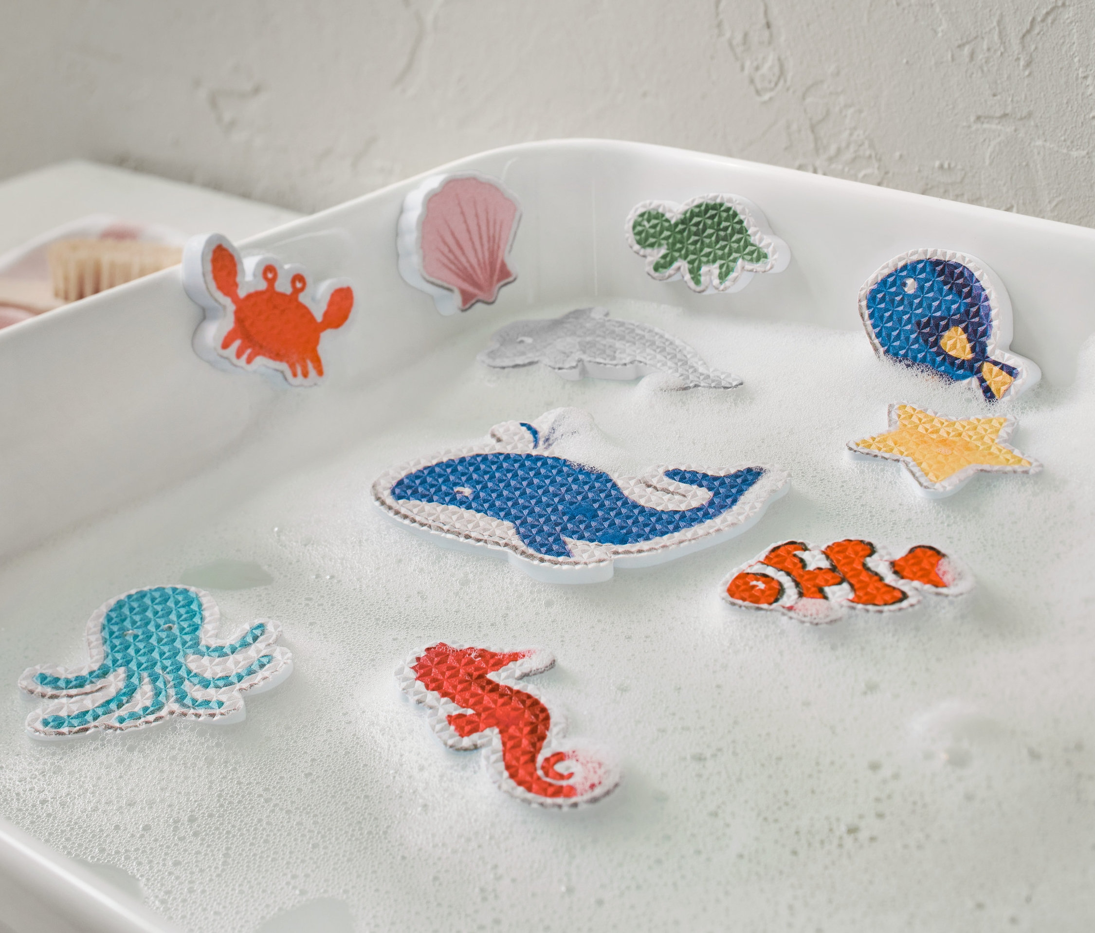 Deset figurek mořských živočichů na hraní do vody ve vaně.