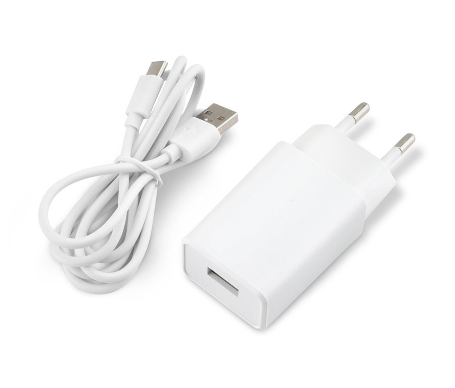 Bílý adaptér a stočený USB kabel leží na bílém povrchu.