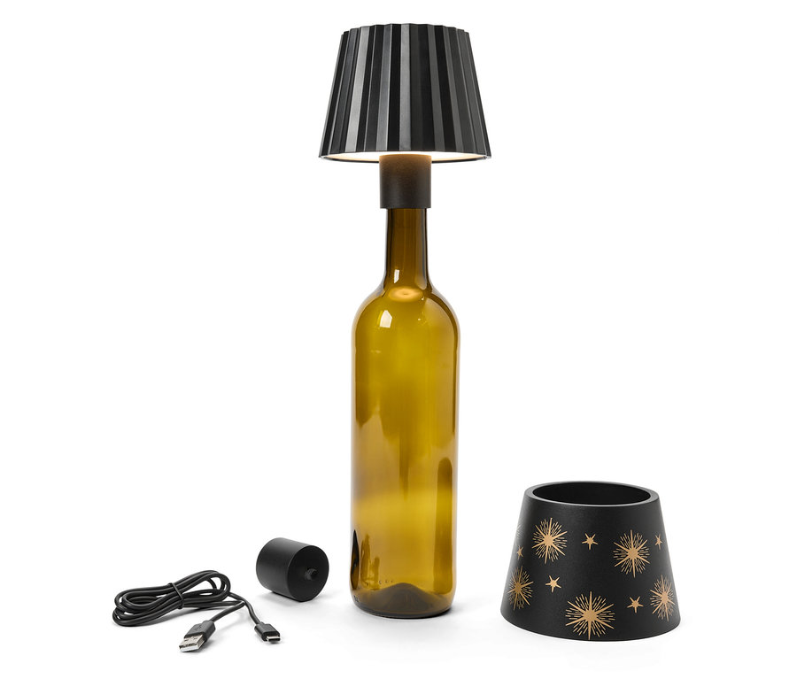 Lampa s černým stínidlem na lahvi, vedle USB kabel, černý válec a stínidlo s hvězdami.