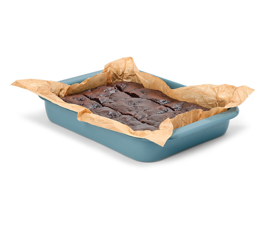 Čokoládové brownies v modré pekáči s pečícím papírem.
