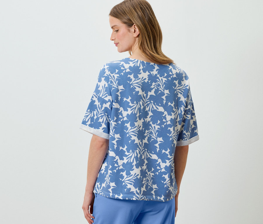 Žena má na sobě světle modrou mikinu s potiskem.