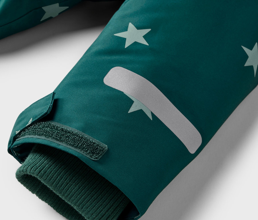 Detail rukávu bundy s hvězdami a suchým zipem.