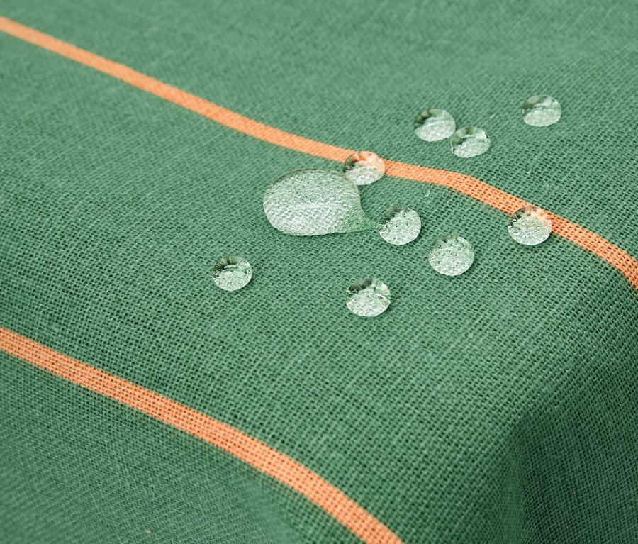 Detail umývatelného ubrusu cca 90 x 90 cm s proužky a kapkami vody.