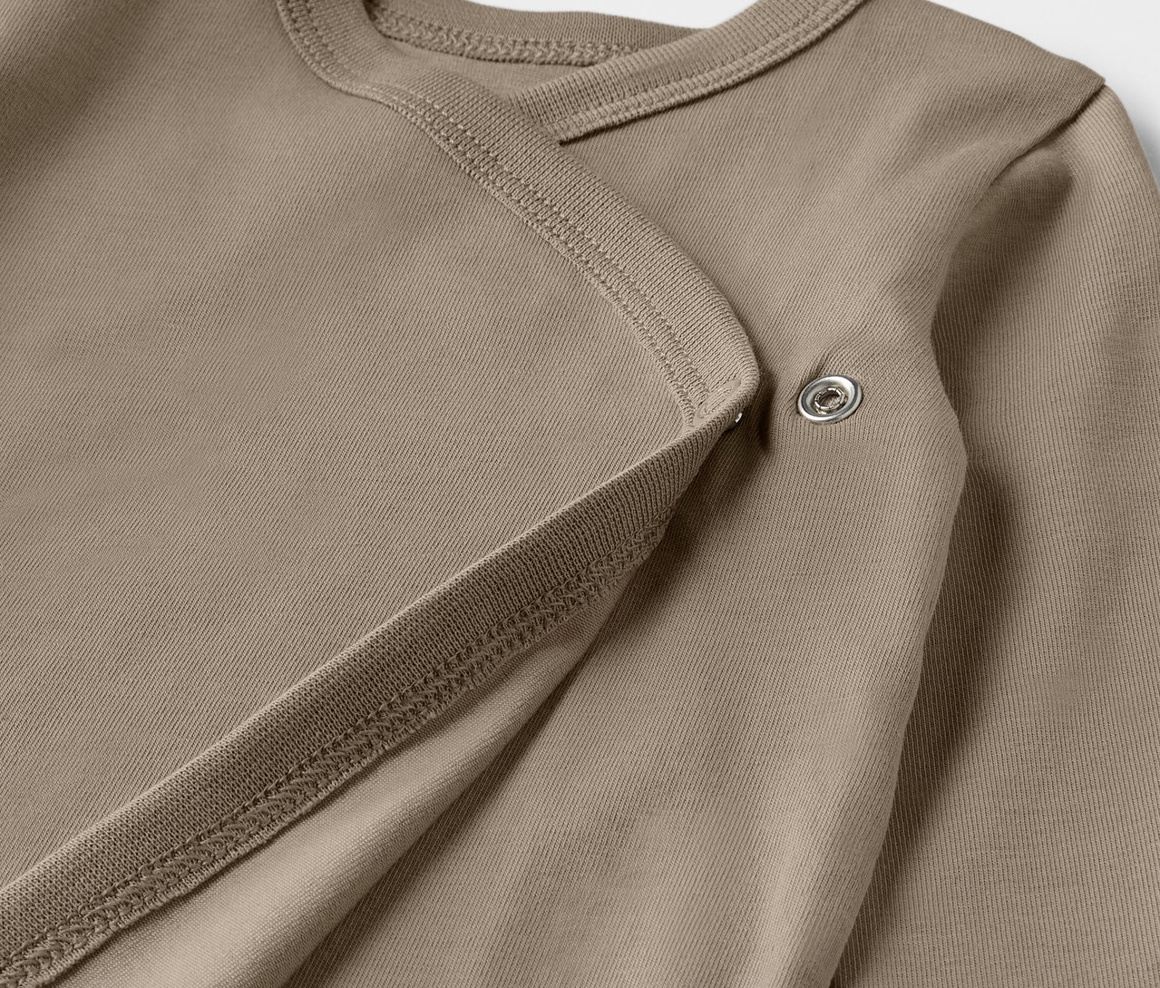 Detail hnědého rostoucího body pro miminka z pětidílné sady.