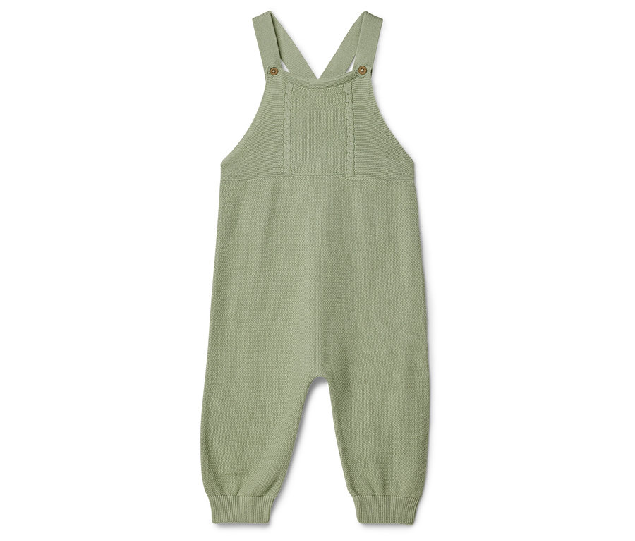 Na bílém pozadí leží jeden světle zelený pletený dětský overal s ramínky.