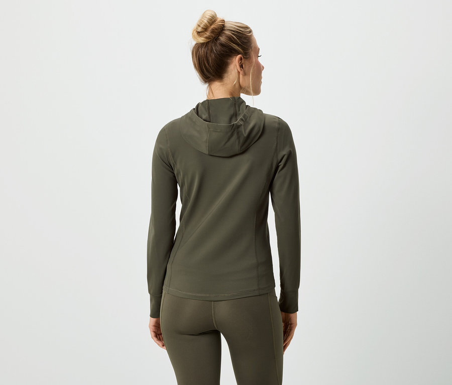 Pohled zezadu na ženu s vlasy v drdolu, oblečenou do olivově zelené mikiny s kapucí a legín.