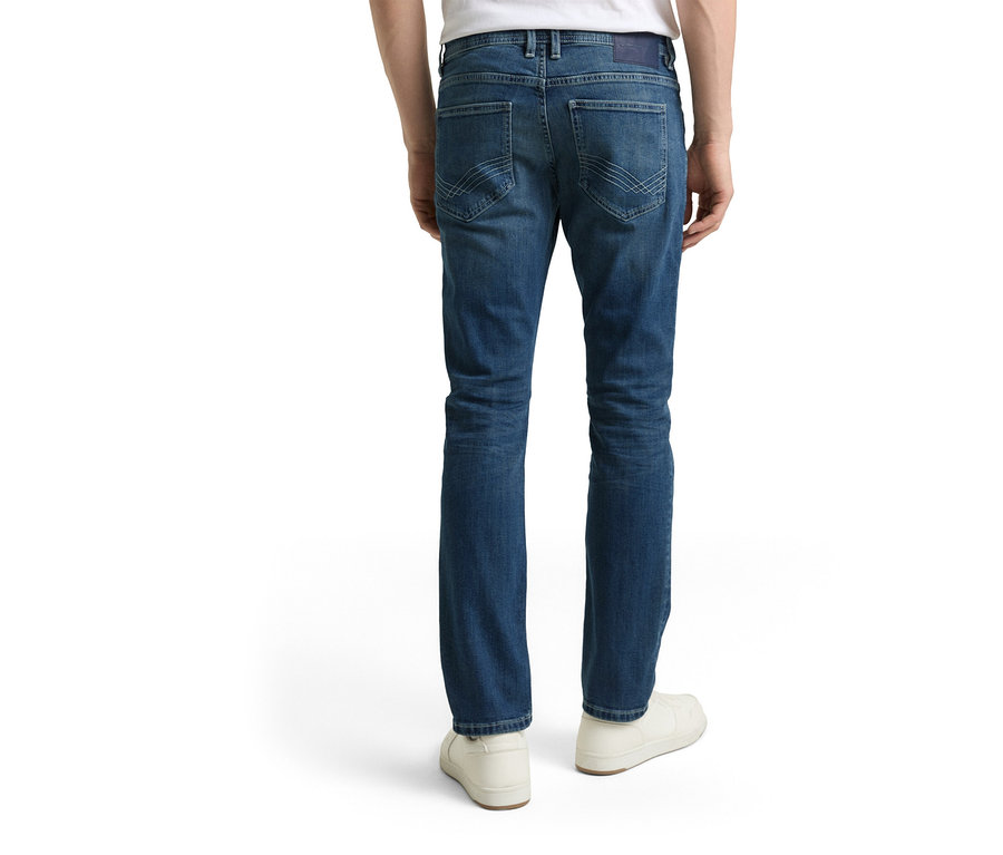 Muž zezadu v džínech Tom Tailor TT MARVIN STRAIGHT se strečovým materiálem, Used Mid Stone Blue Denim a bílých botách.