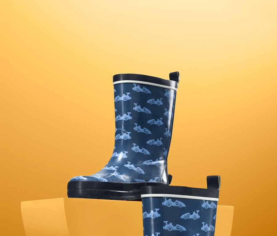 Dvoje modré holínky do deště s potiskem na oranžovém pozadí.
