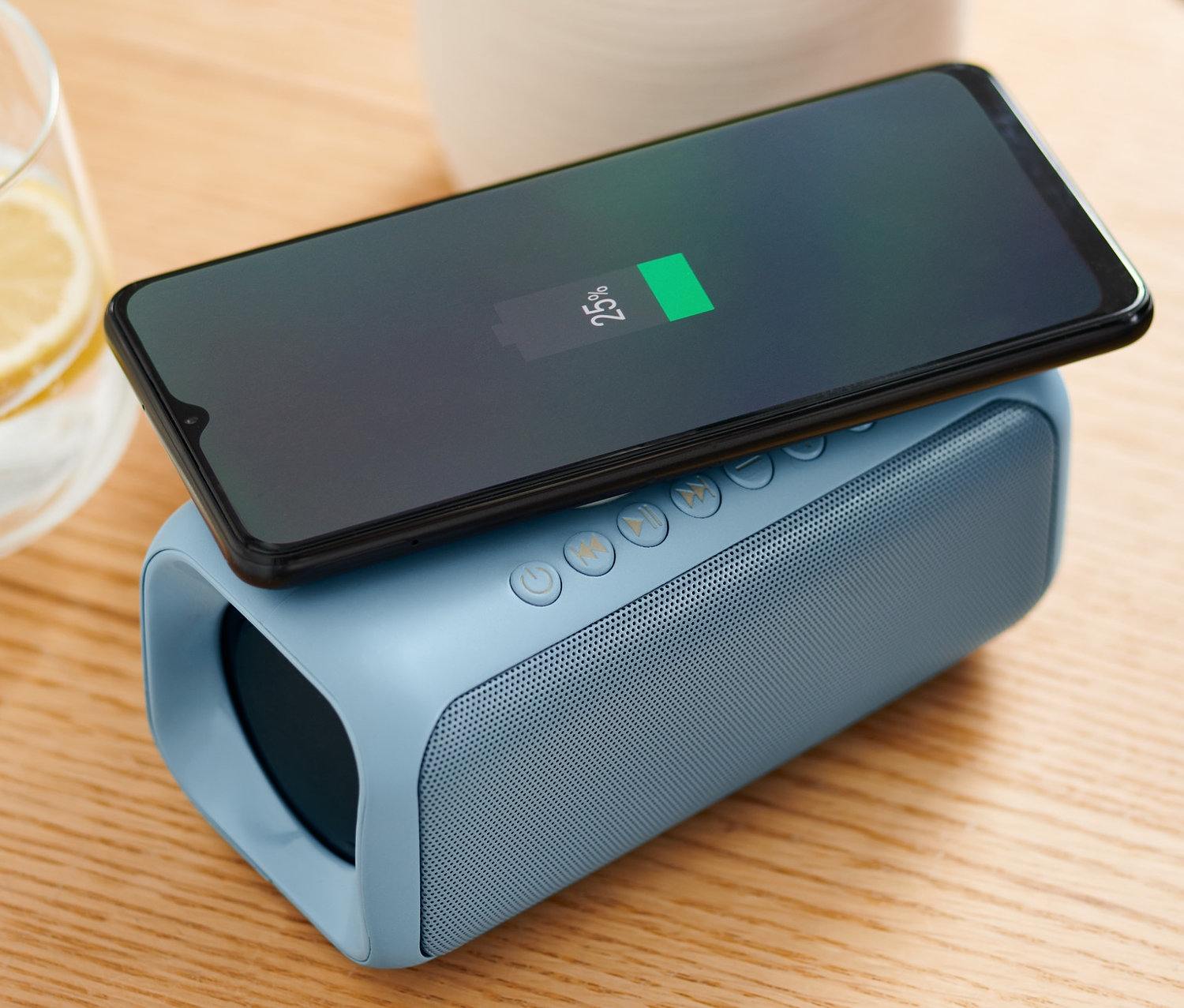 Mobilní telefon se nabíjí na reproduktoru s bezdrátovým nabíjením.