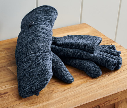 Pár modrých odklápěcích palčáků z pleteného fleecu leží na dřevěné lavici vedle modré tašky.
