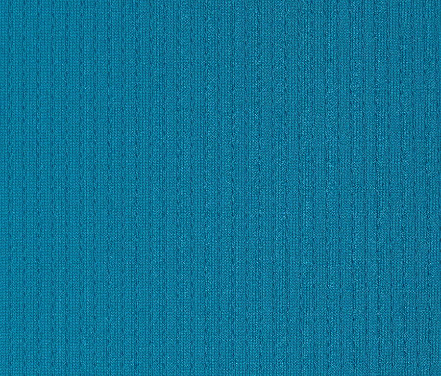 Detailní záběr na funkční triko v tyrkysové barvě.