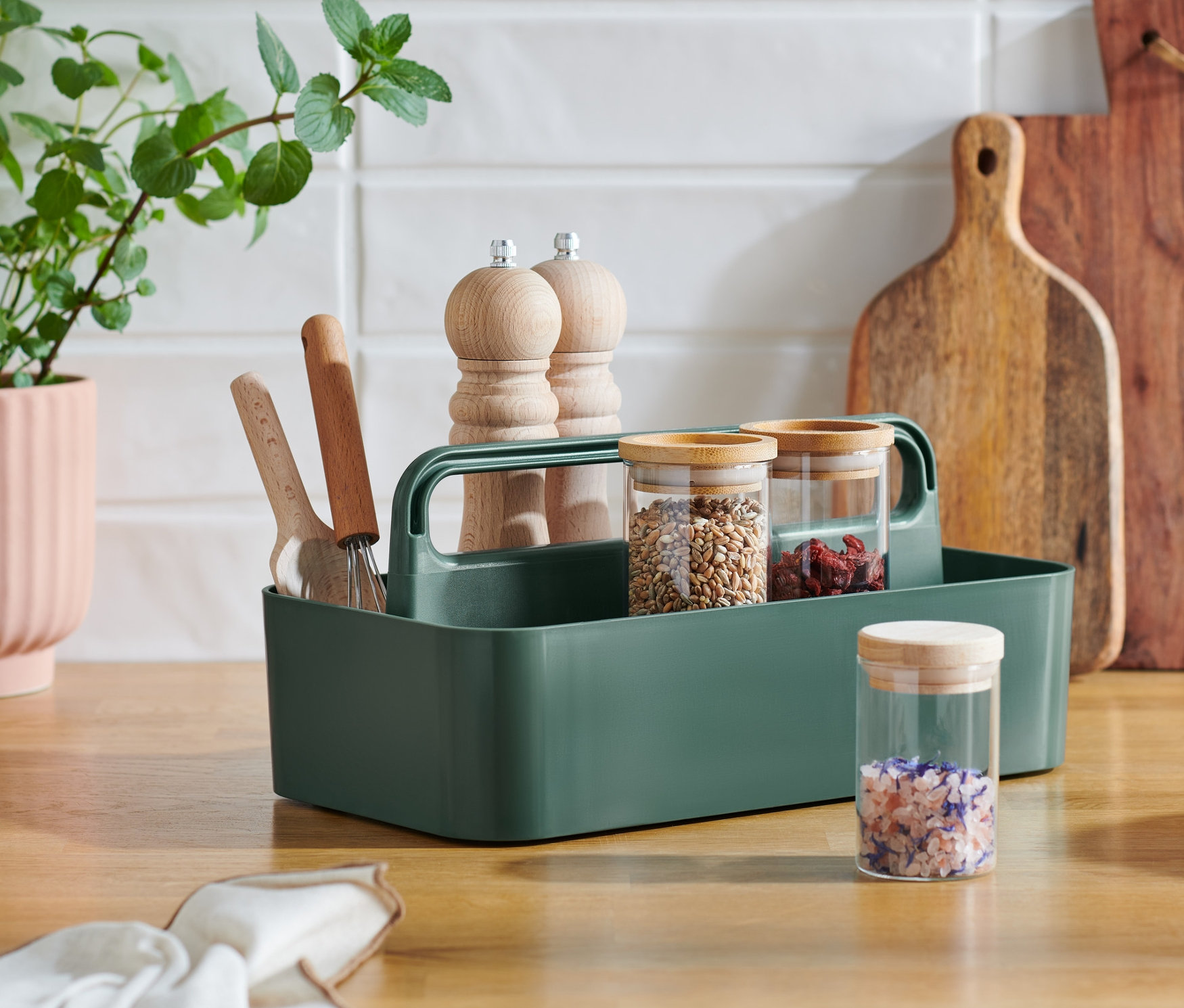 Na lince stojí víceúčelový košík, vedle květináč a prkénka.