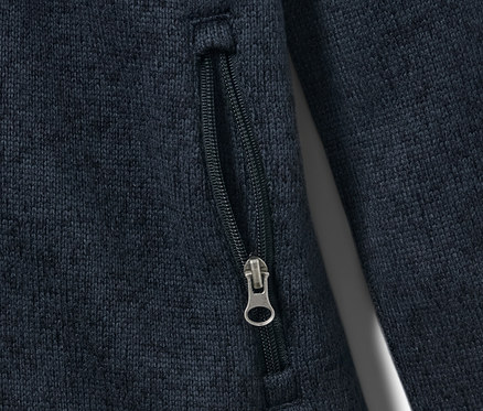 Detail dětské mikiny z pleteného fleecu s kapsou na zip.