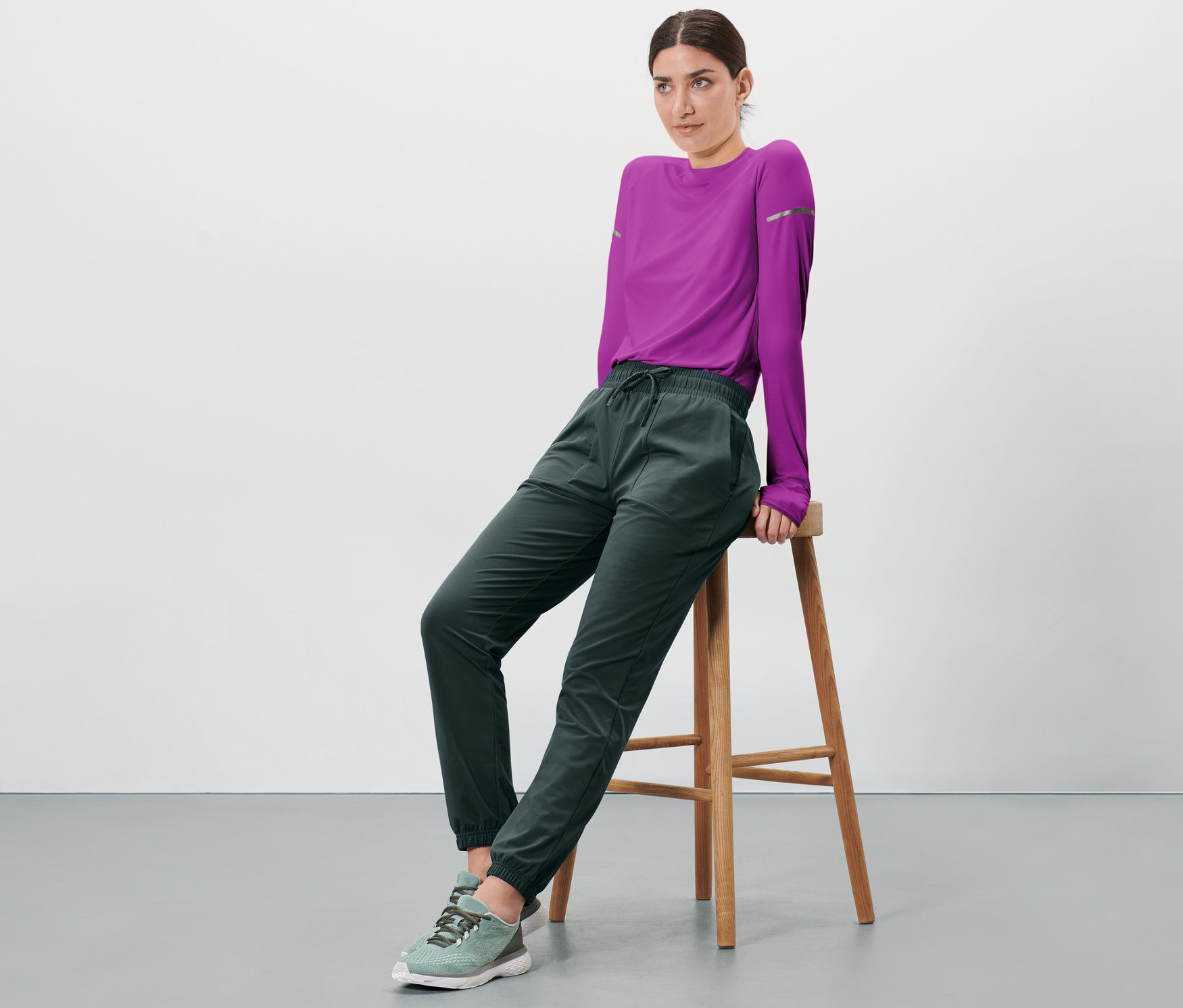 Žena sedí na stoličce a má na sobě funkční termokalhoty.