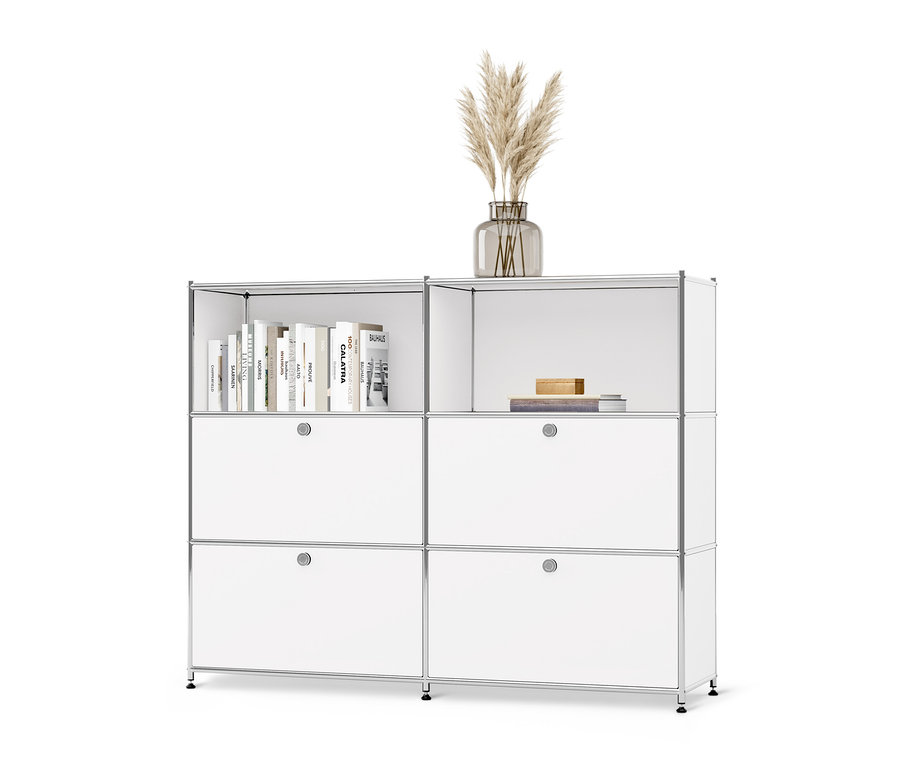 Bílá kovová komoda CN3 s přestavitelnými výklopnými dvířky, na ní váza s trávou a knihy.