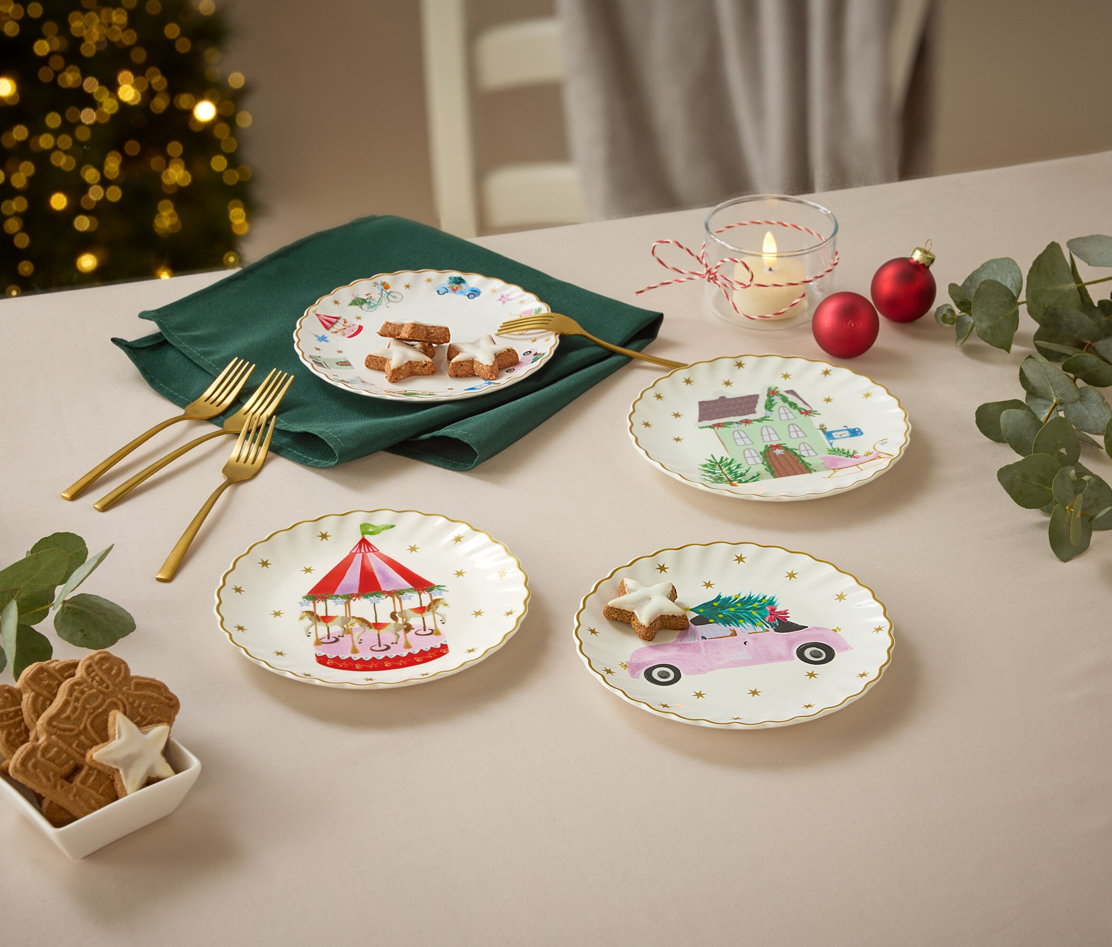 Čtyři talíře s vánočními motivy na stole s vánočními ozdobami.