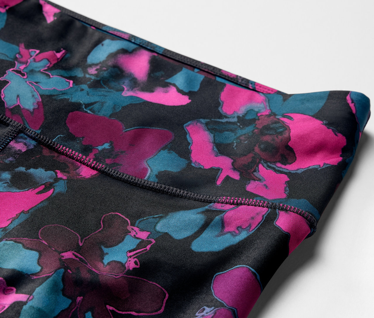 Detail sportovních legín s květinovým vzorem.