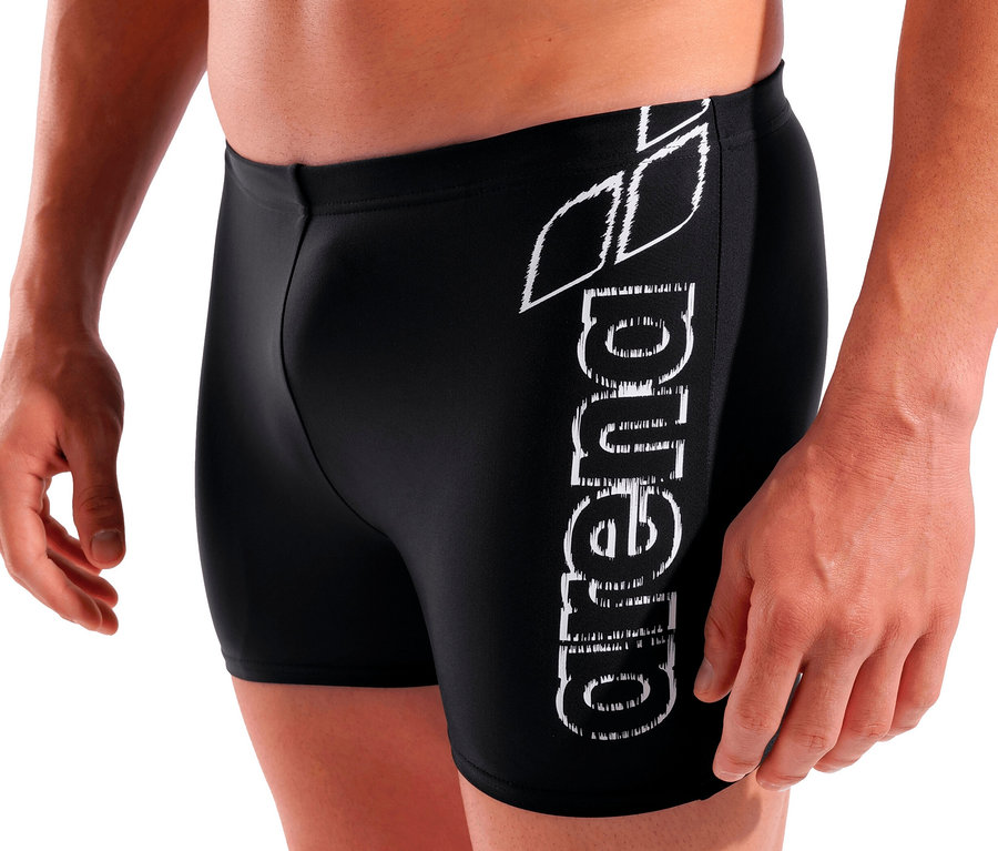 Muž pózuje v černých plavkách Arena Scratchy.