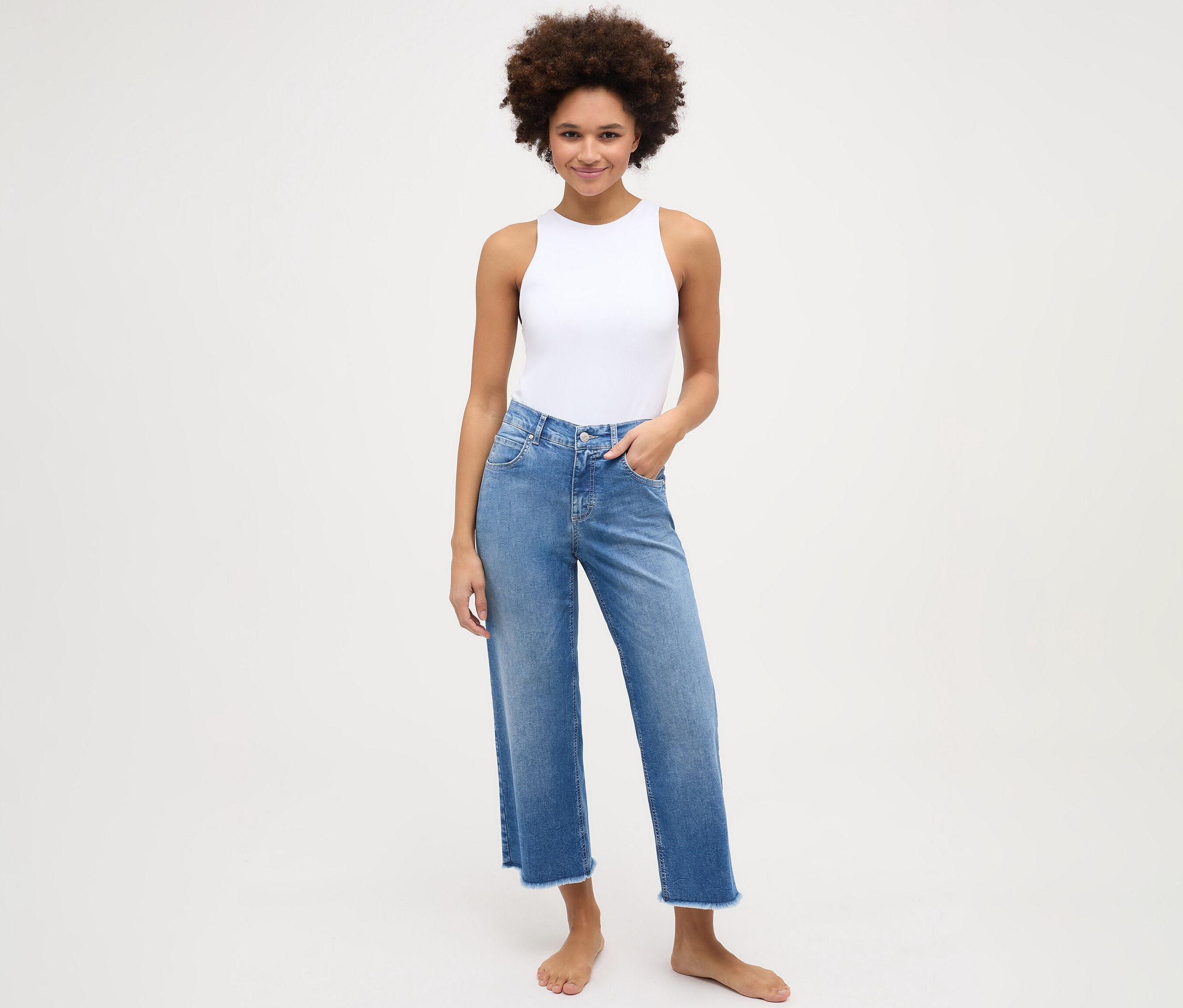 Žena má na sobě džíny Angels »Linn« culotte s roztřepenými nohavicemi, light blue.