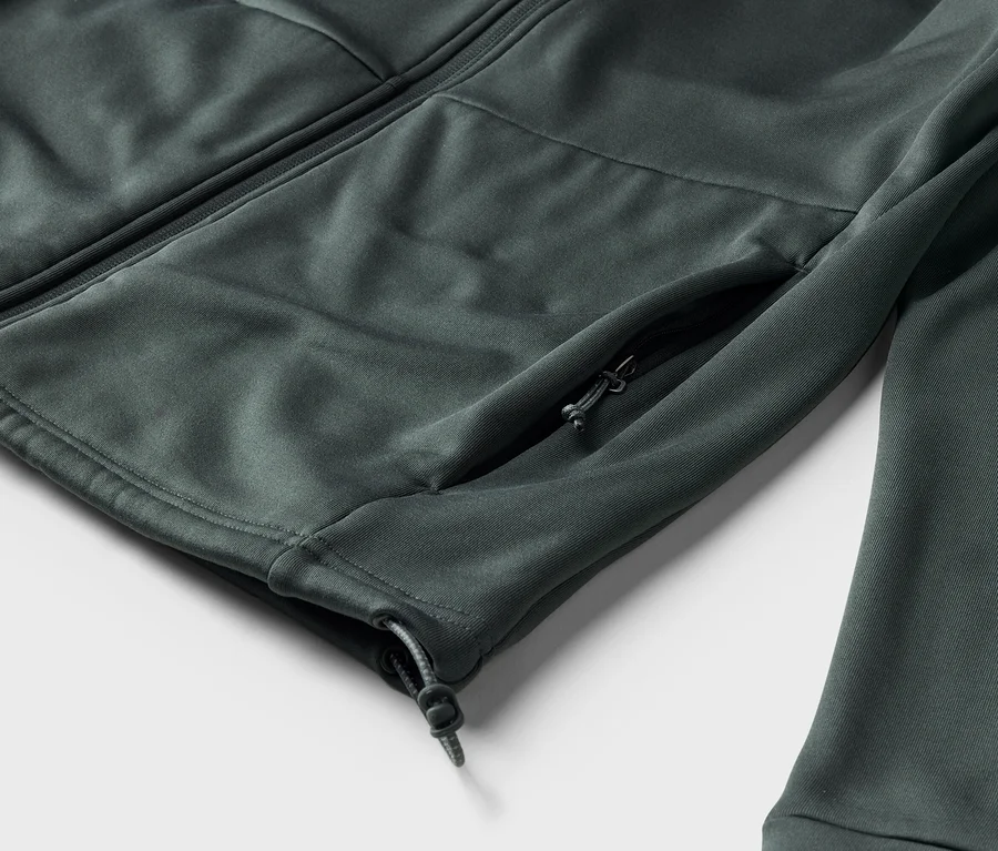 Detail šedé bundy se zipem a boční kapsou na zip.