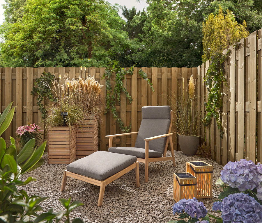 Zahrada se šedým křeslem a stoličkou, dvěma bambusovými solárními lucernami a 5 LED solárními zápichy.