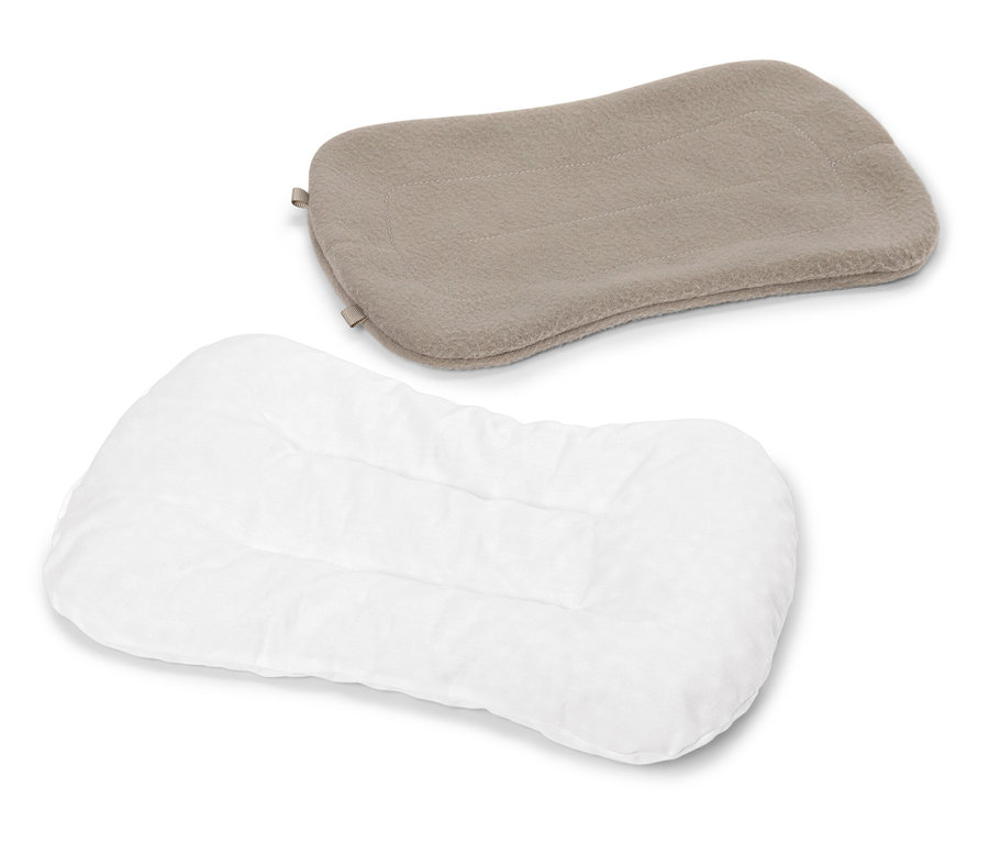 Bílý prošívaný polštář leží pod béžovým polštářem na bílém pozadí.