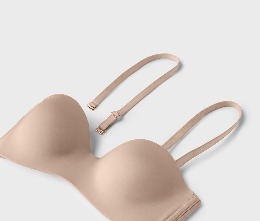 Tělová podprsenka bez ramínek s odnímatelnými ramínky leží na světlém pozadí.