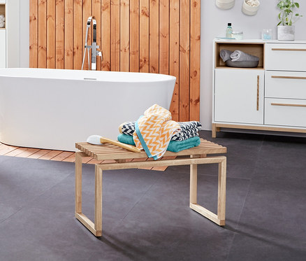 Interiér koupelny s umyvadlovou skříňkou »Eklund« se dvěma zásuvkami, žebříkovým regálem z dubového dřeva a žakárovými osuškami.