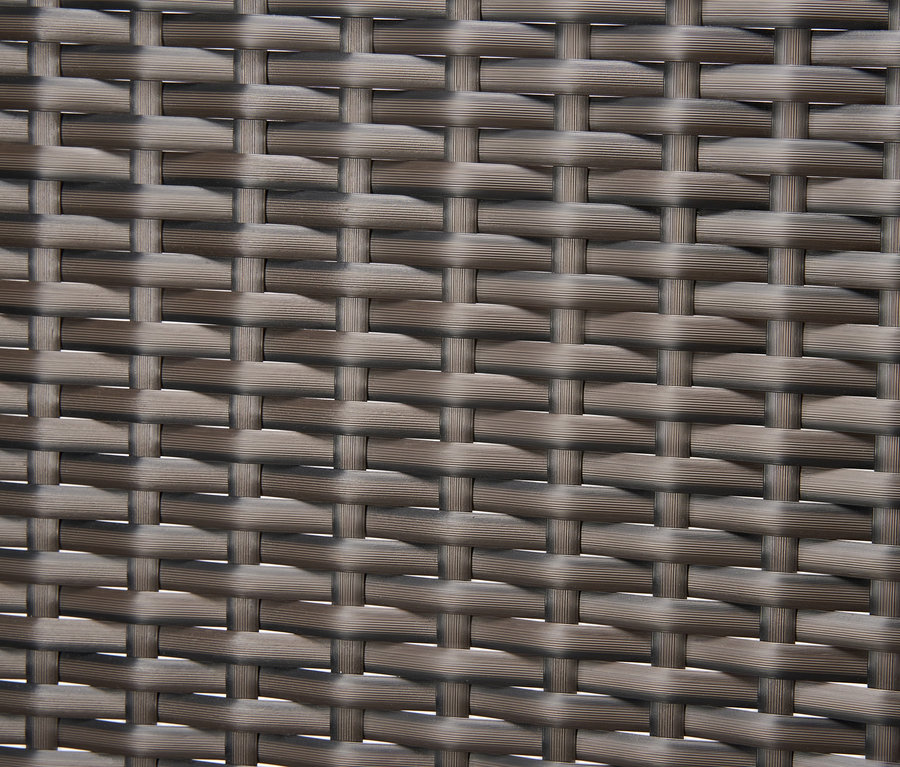 Detailní záběr polyratanového výpletu lounge nábytku.