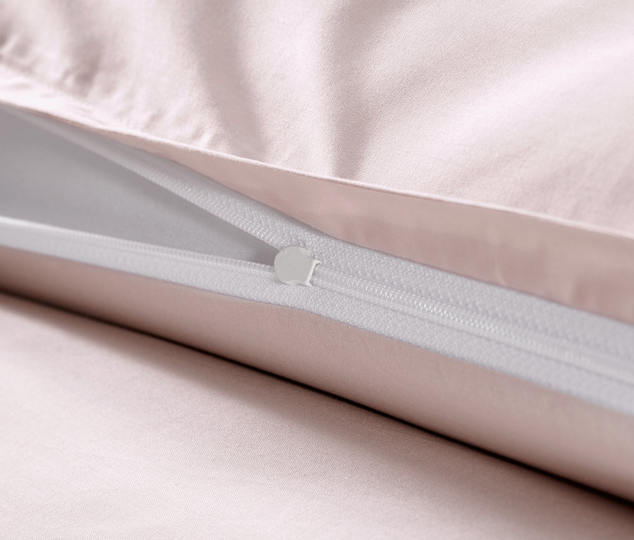 Detail růžového povlečení z bavlněného saténu se zipem.